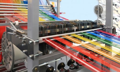 multi-colored yarns in the textile machine. Image: @DIrectIndustry e-Magazine. https://emag.directindustry.com/wp-content/uploads/sites/3/iStock-178631224.jpg